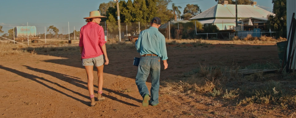 Woman and man walking in outback Australia as the sun sets
