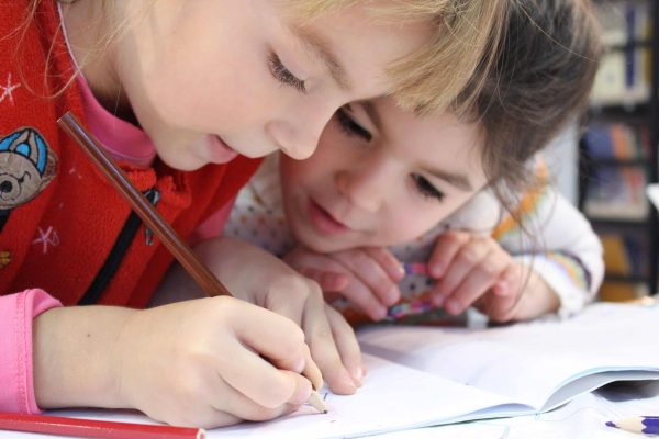 Two children looking at a page drawing